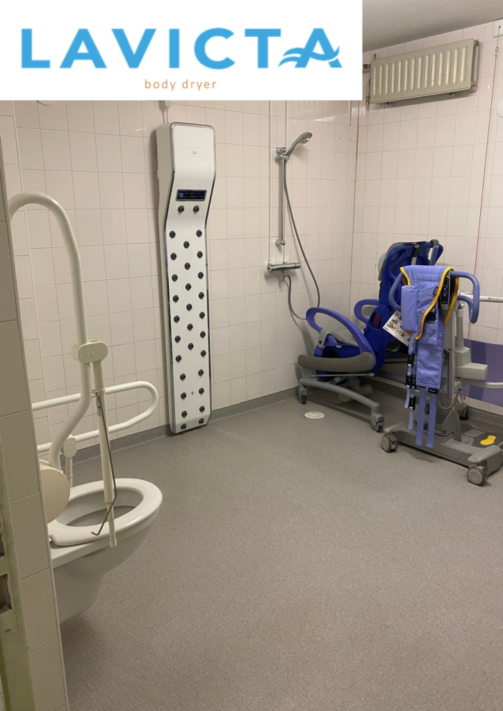 Lavicta lichaamsdroger in een zorgbadkamer met toilet en tillift